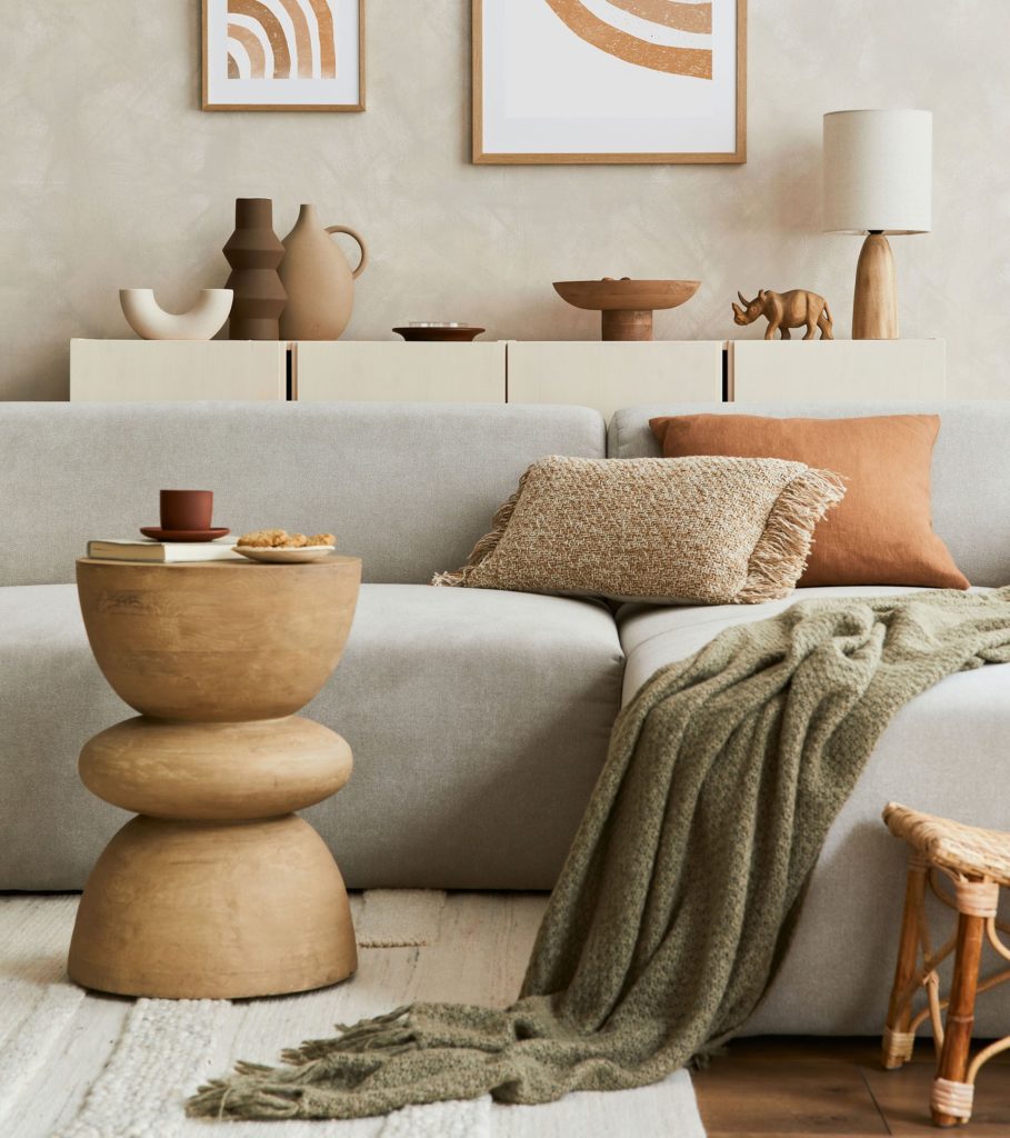 Elegant living room interior design with mock up poster frame, grey corner sofa, coffee table and personal accessories. Pastel neutral colours. Template.